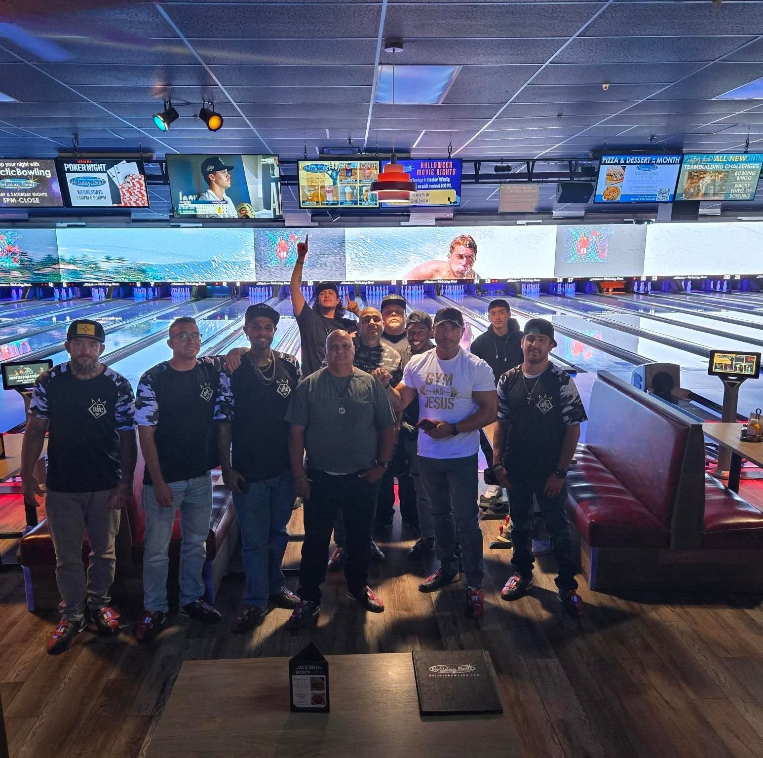 Men of Under HIS Construction wearing UHC jerseys on a bowling night out together