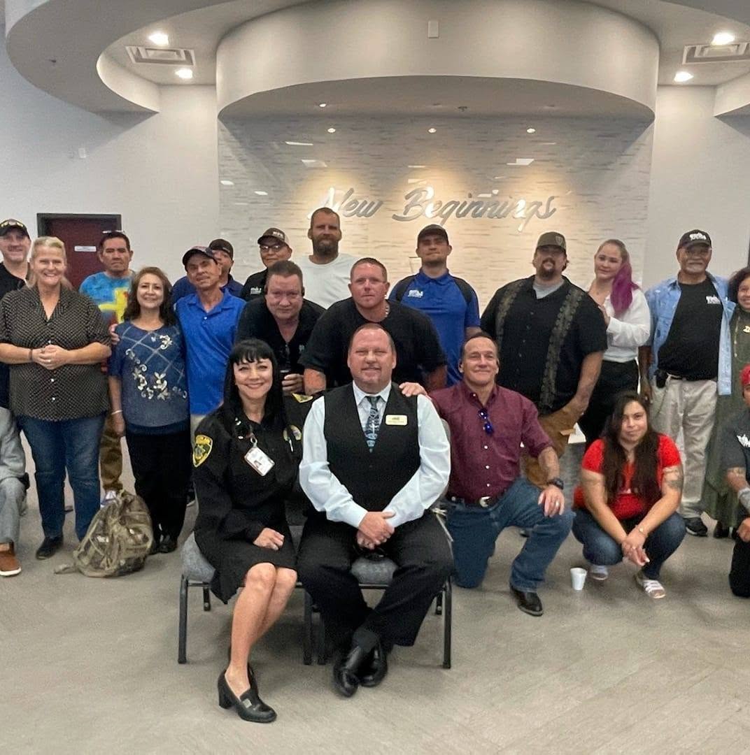 Under HIS Construction residents and staff gathered under a New Beginnings sign at church