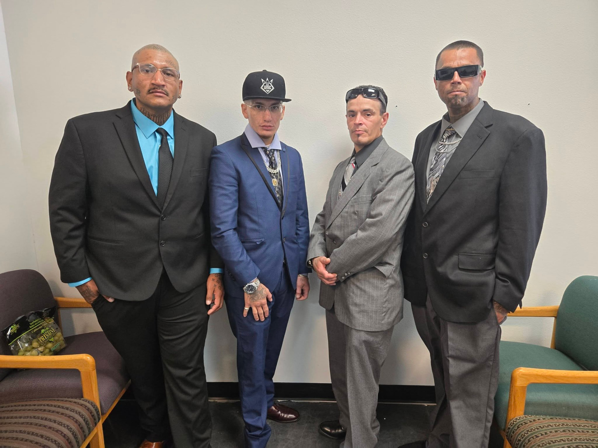 Four men from Under HIS Construction dressed in suits before a ceremony